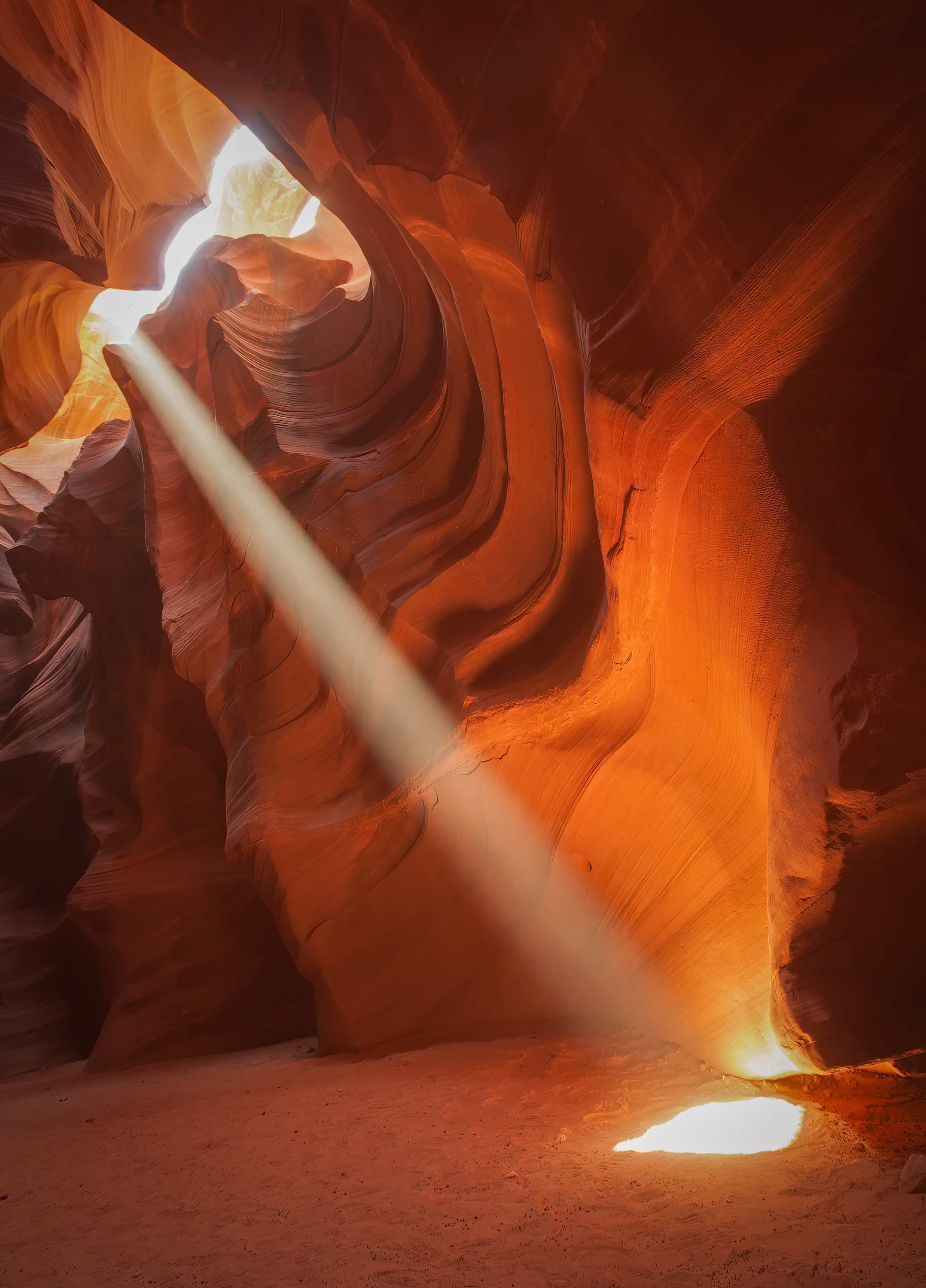 The iconic vertical light beam inside Upper Antelope Canyon, shining through a narrow opening in the sandstone ceiling