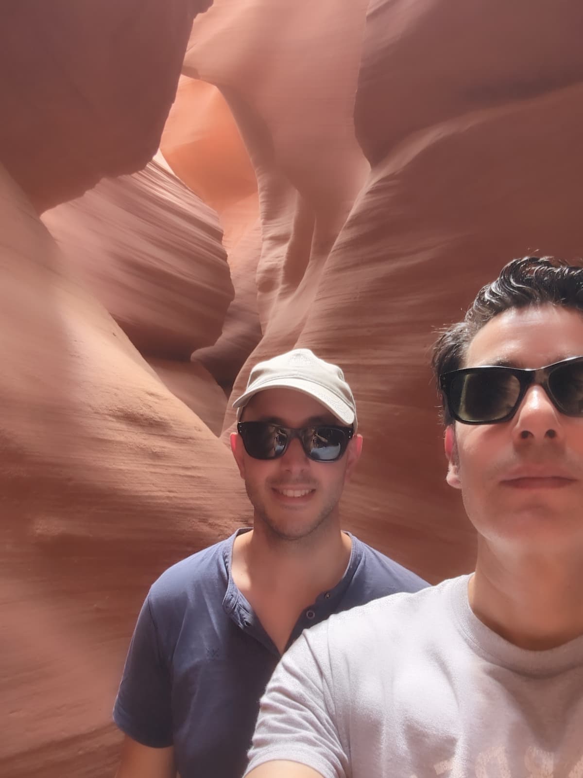 Diego and a companion inside Upper Antelope Canyon, sandstone walls curving around them